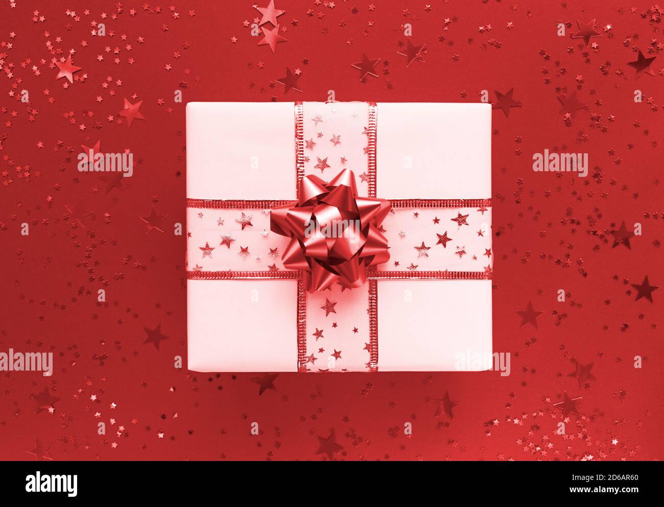 Geschenkbox und Sterne auf rotem Hintergrund. Monochrom flach liegend. Stockfoto