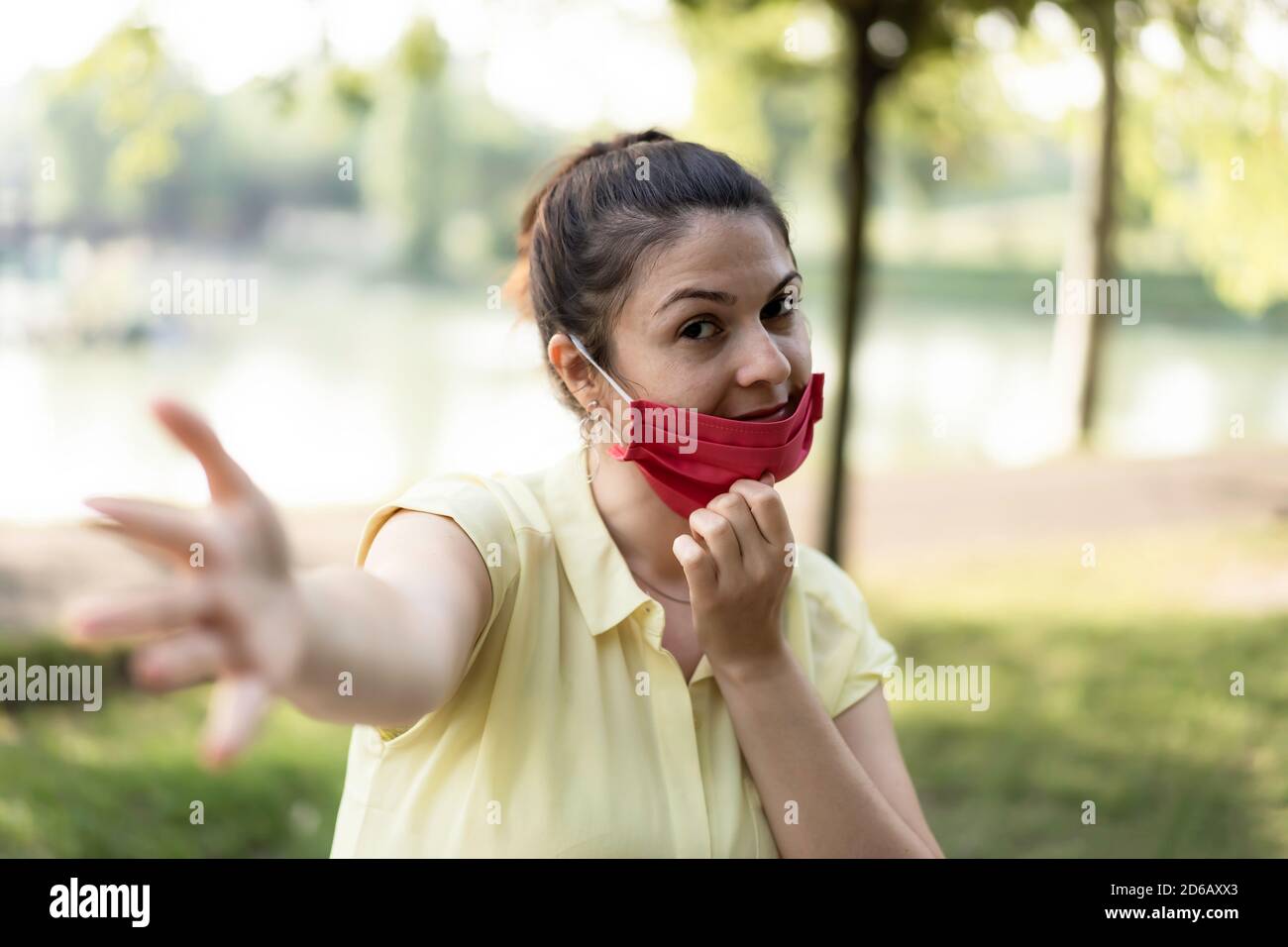 Lächelnde Frau genießen das Leben im Park atmen frische Luft Nach Coronavirus Ausbruch - Neue normale Konzept der Menschen mit Lustige absenkende Schutzmaske Stockfoto