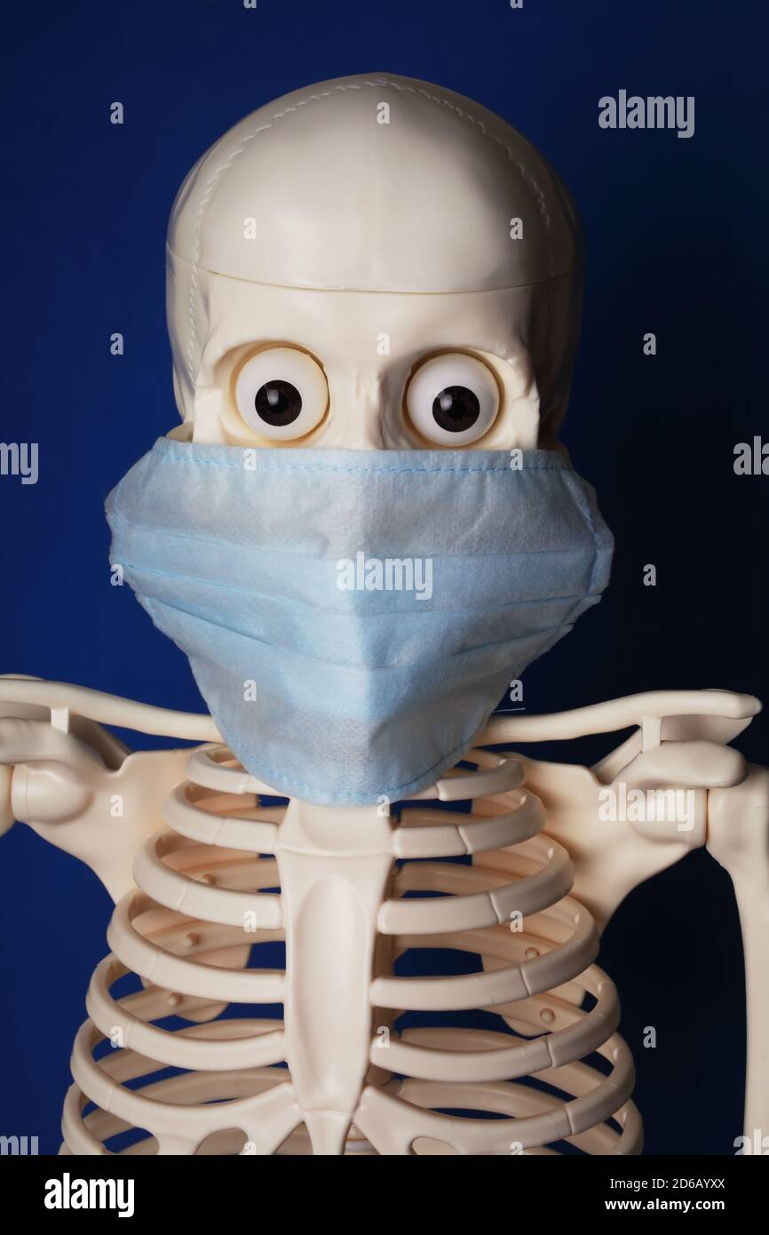 Knstliches menschliches Skelett mit Augen in einer medizinischen Maske auf  blauem Hintergrund, Nahaufnahme Stockfotografie - Alamy