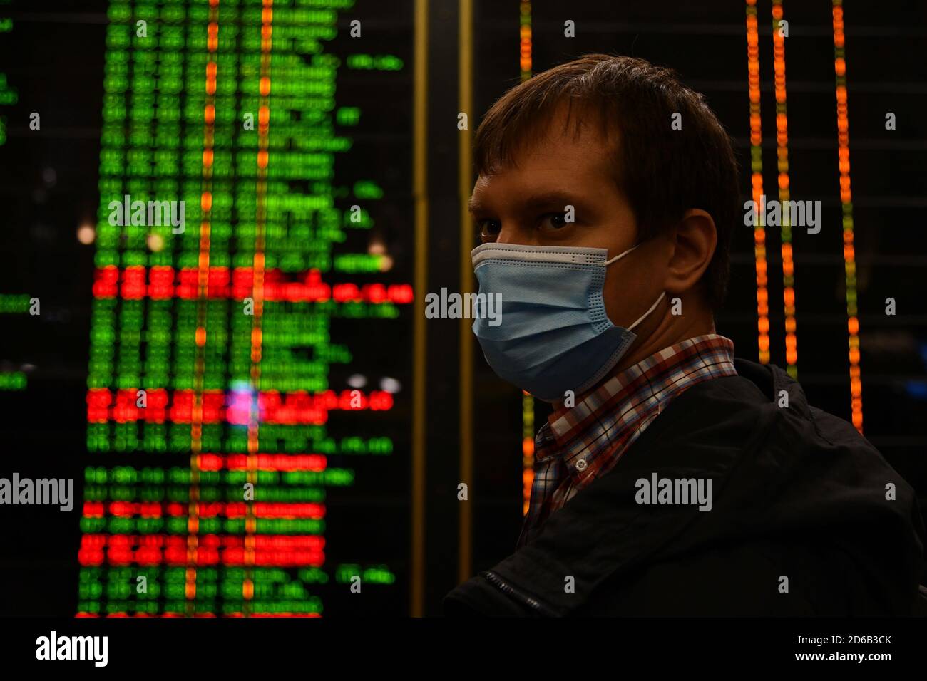 Passagiere an Bahnhöfen und Flughäfen halten sich an die Einschränkungen der COVID-19-Pandemie: Sie tragen Masken und beobachten soziale Distanzierungen. Stockfoto