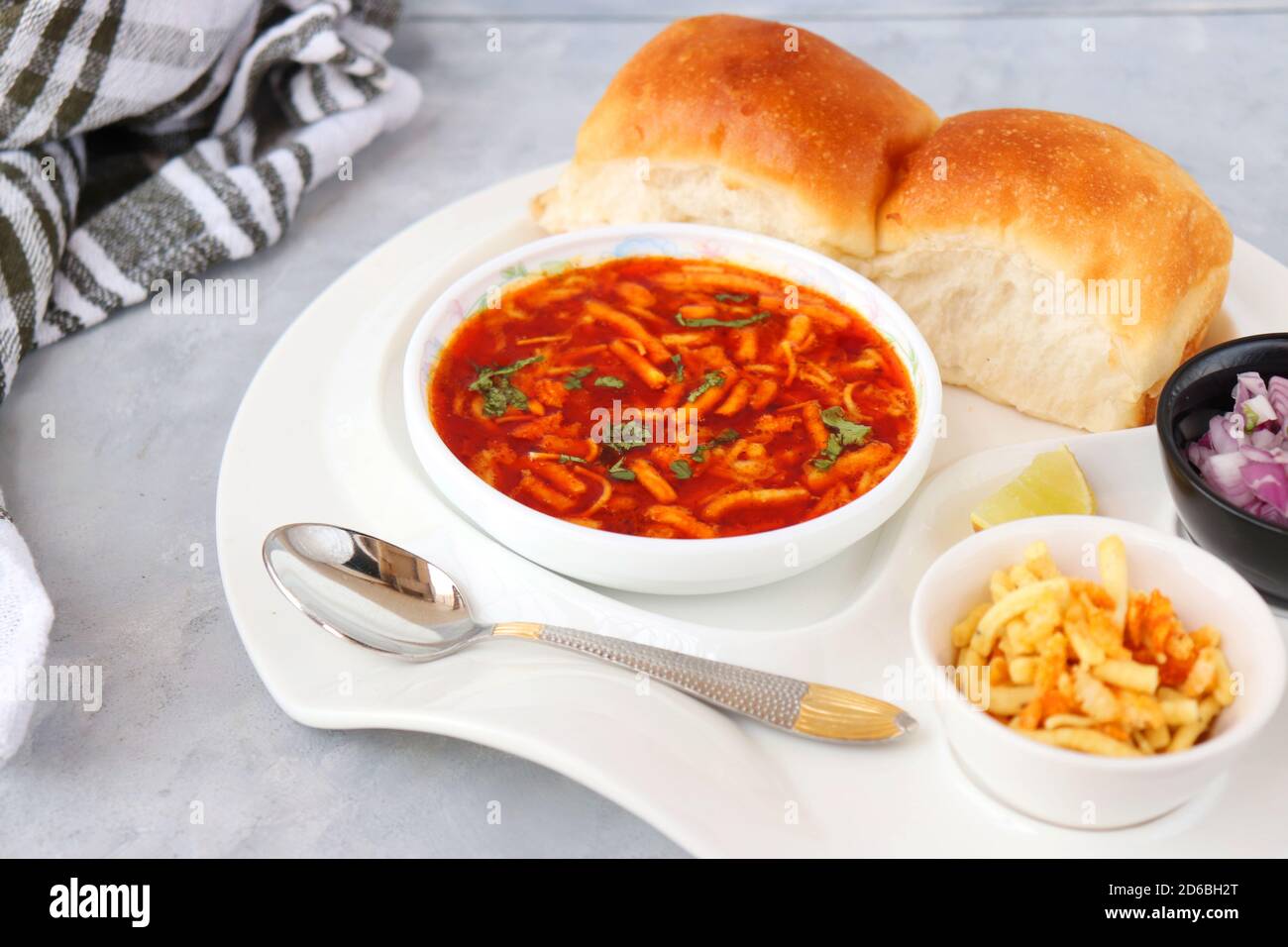 Spicy Misal Pav oder Sal Pav ist ein traditioneller Snack oder Chaat-Essen aus Maharashtra, Indien. Serviert mit gehackten Zwiebeln, Zitronenkeilchen und farsan. Stockfoto