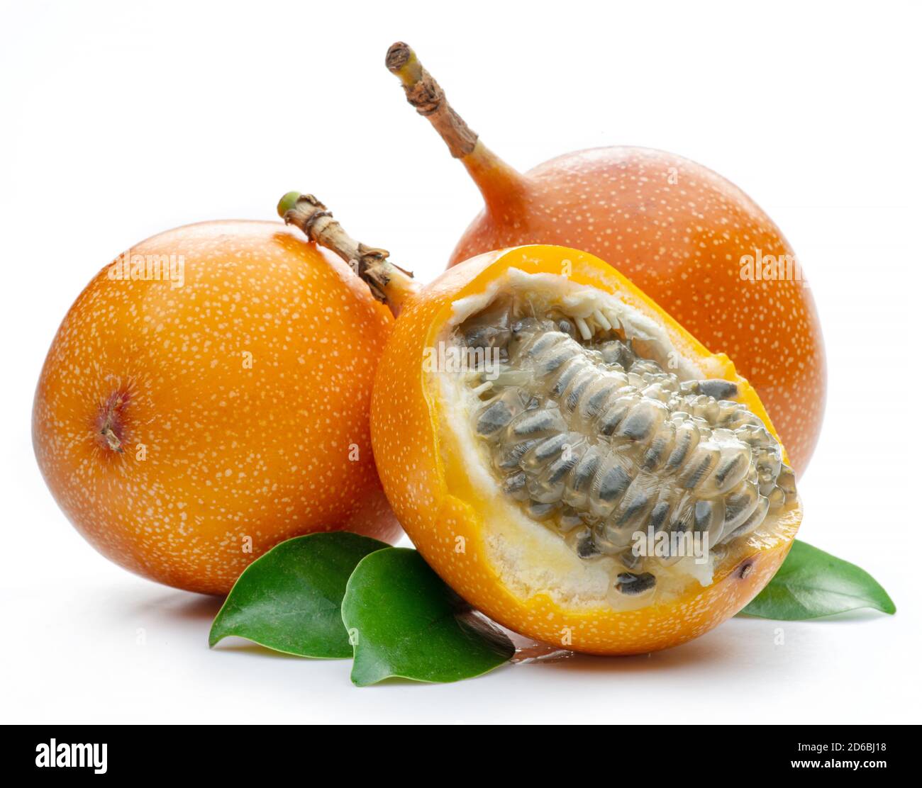 Granadilla mit Blättern und Passionsfrucht halb isoliert auf weißem Hintergrund. Stockfoto