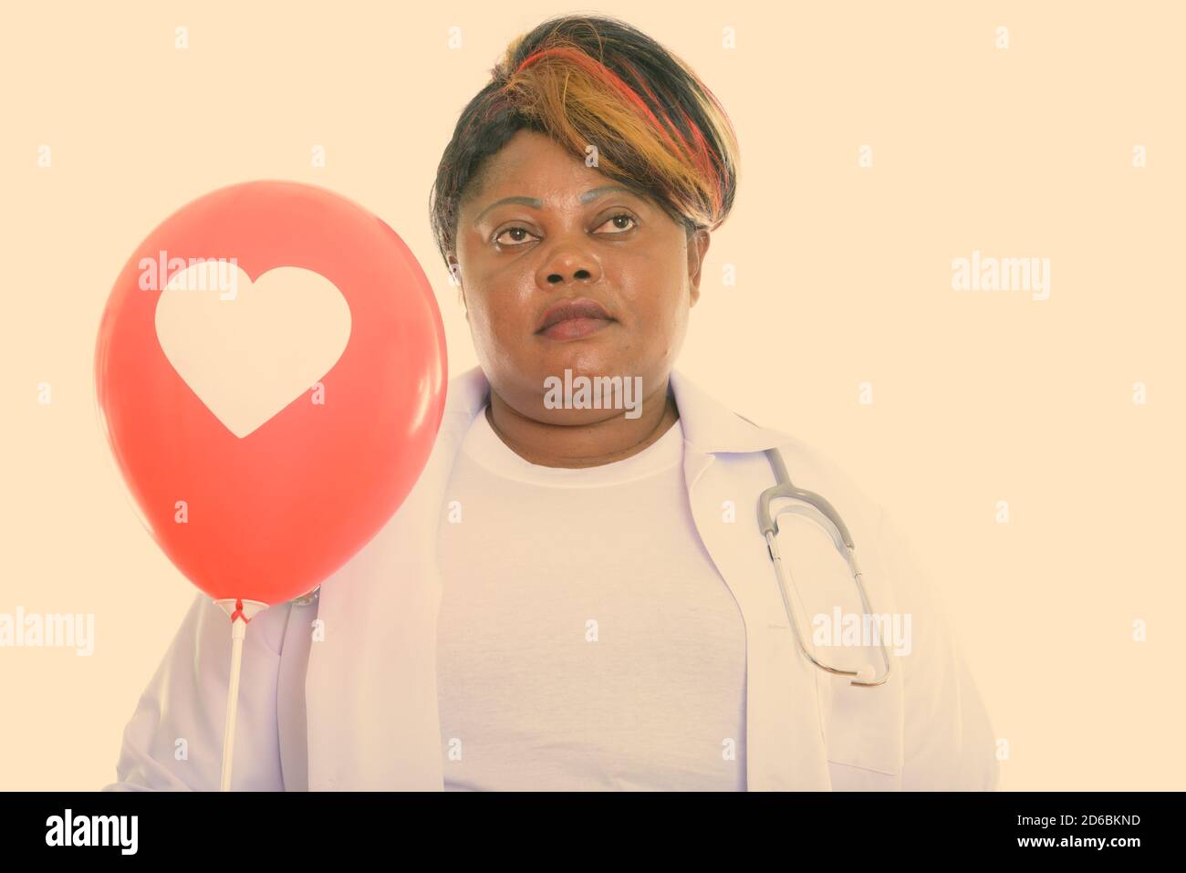 Nachdenklich fett schwarz afrikanisch Frau Arzt hält roten Ballon mit Herzzeichen Stockfoto