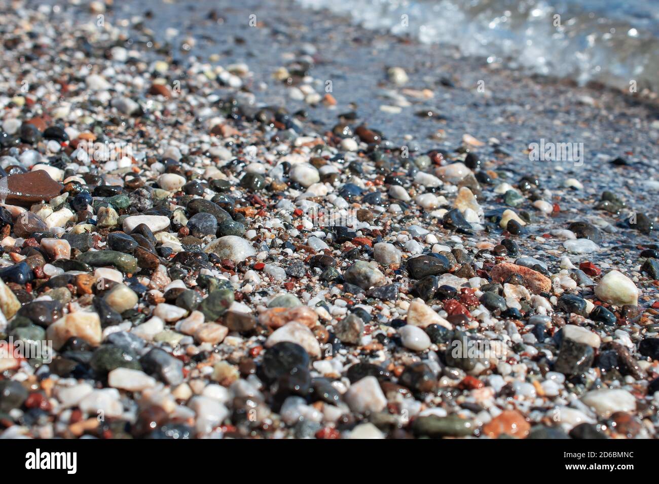 Bunte Strandsteine Hintergrund. Mehrfarbige Kieselsteine am Strand, von Wellen gewaschen. Abstrakter Hintergrund. Stockfoto