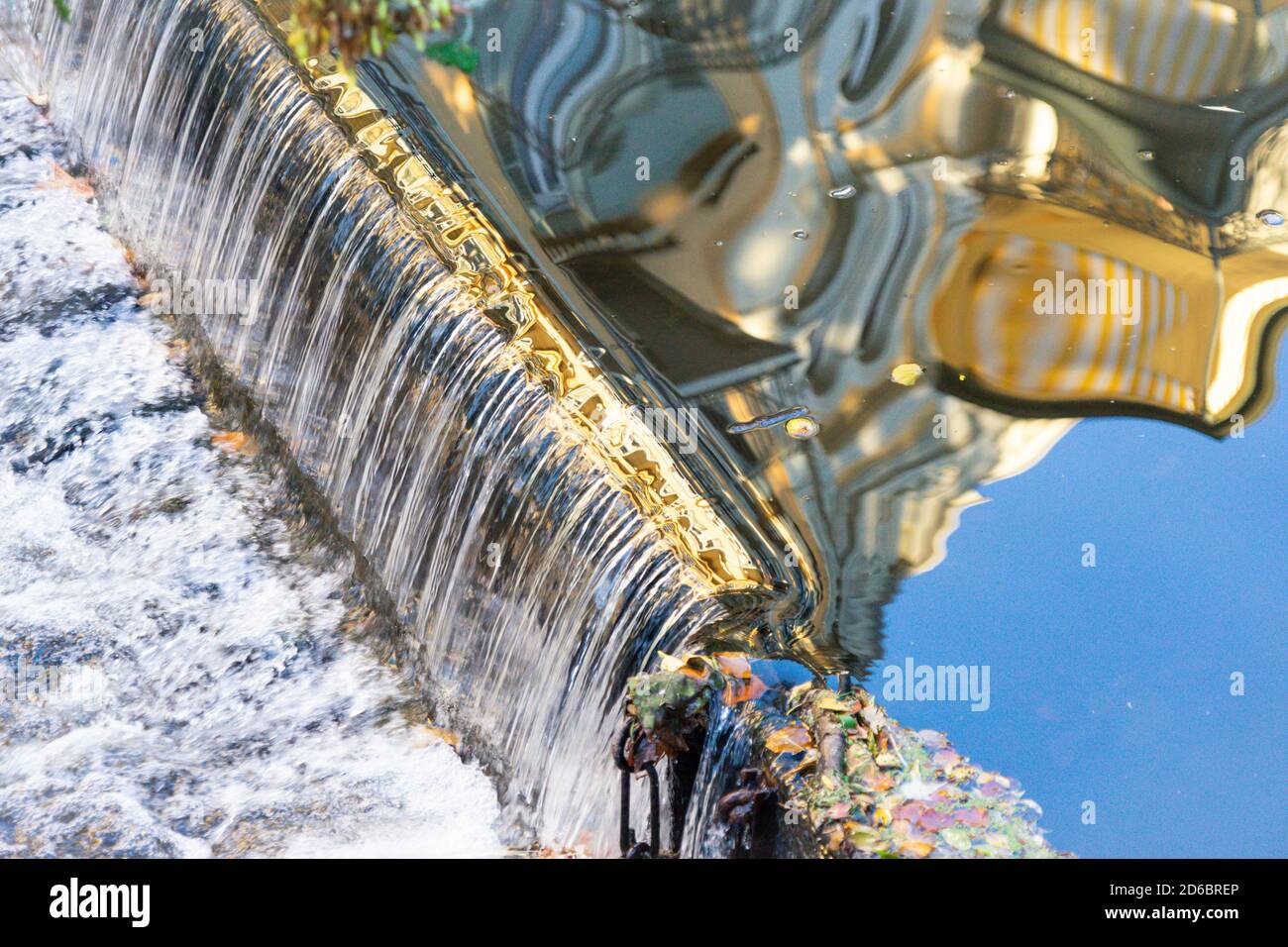 Klassizistische Hausfassade in einem Bach mit einem kleinen gespiegelt Wasserfall Stockfoto