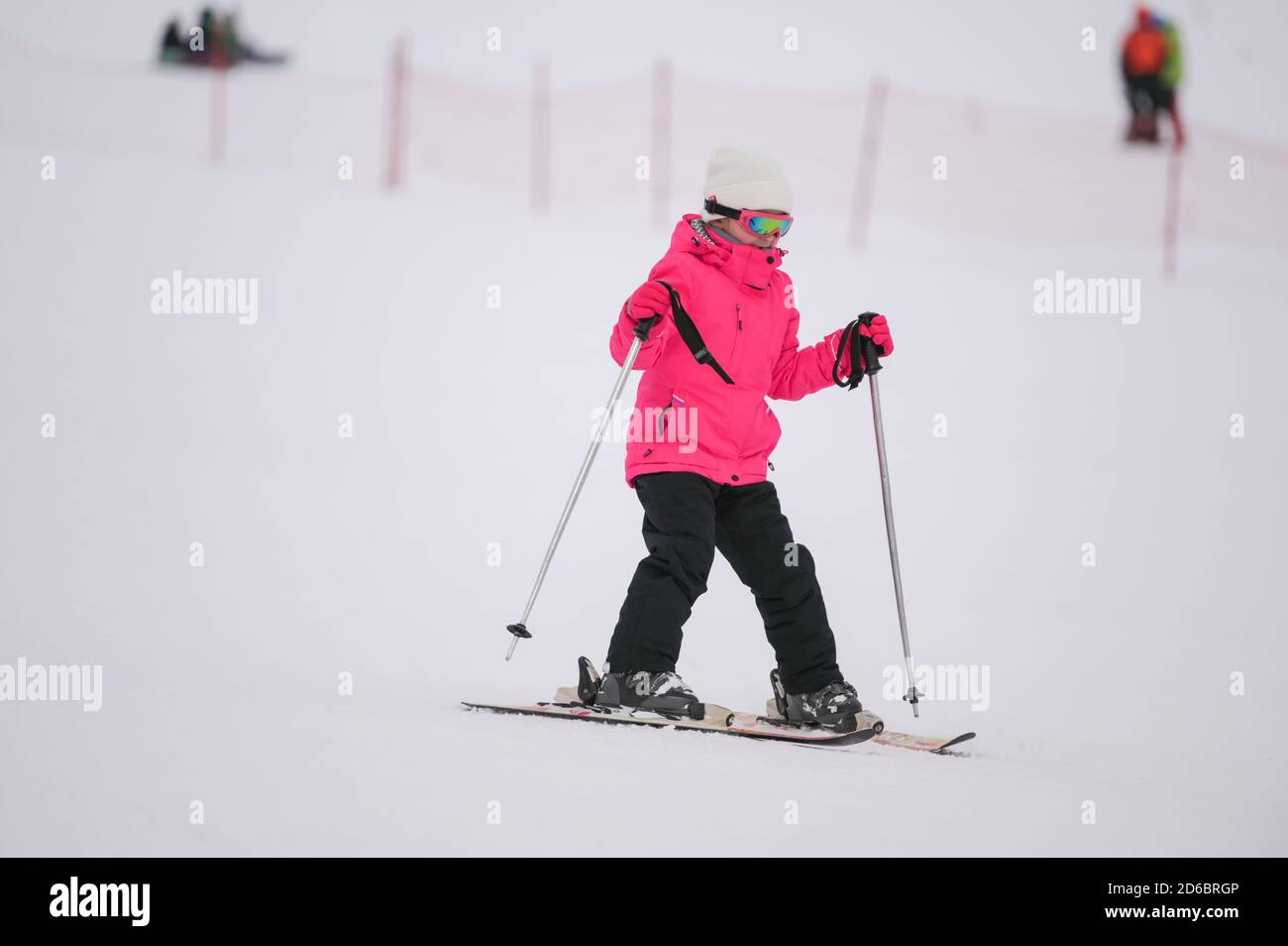 Happy Little Active Mädchen in rosa Skianzug im Winter Skifahren auf weißem Schnee Berg Alpine Piste Resort Freizeit Stockfoto