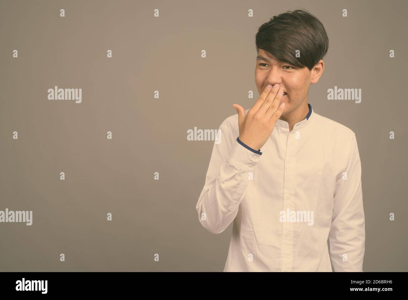 Jungen asiatischen Teenager gegen grauer Hintergrund Stockfoto