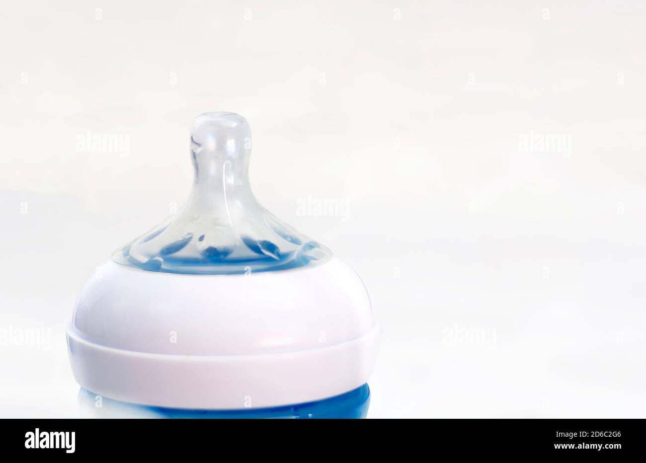 Der transparente Silikon-Sauger einer blauen Babyflasche isoliert auf weißem Hintergrund. Stockfoto