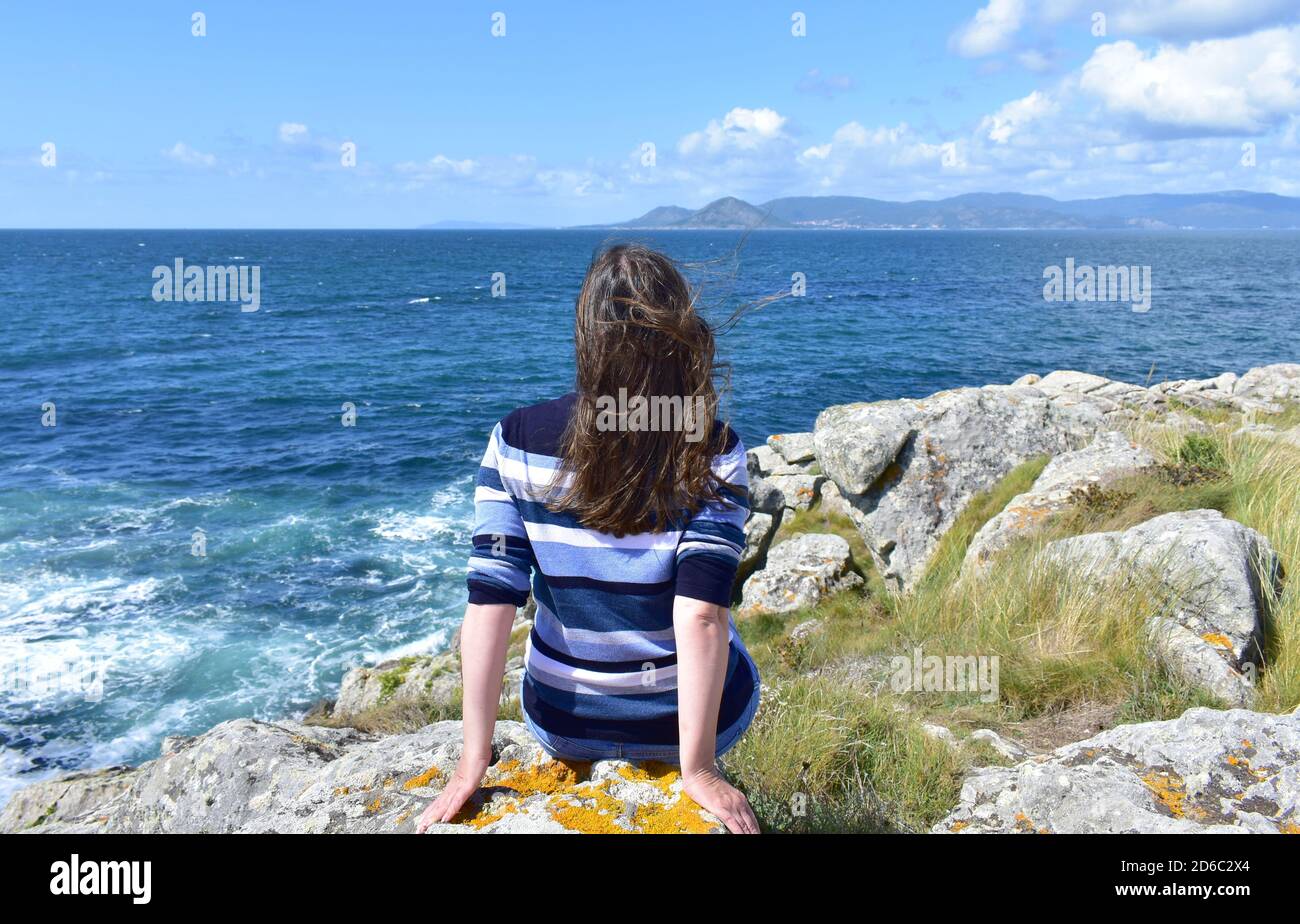 Frau auf einer Klippe mit Blick auf die berühmte Rias Baixas in Galicien, Spanien. Stockfoto