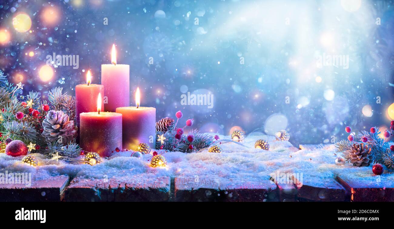 Advent - Vier Lila Kerzen Mit Weihnachtsschmuck In Glänzend Nacht Stockfoto