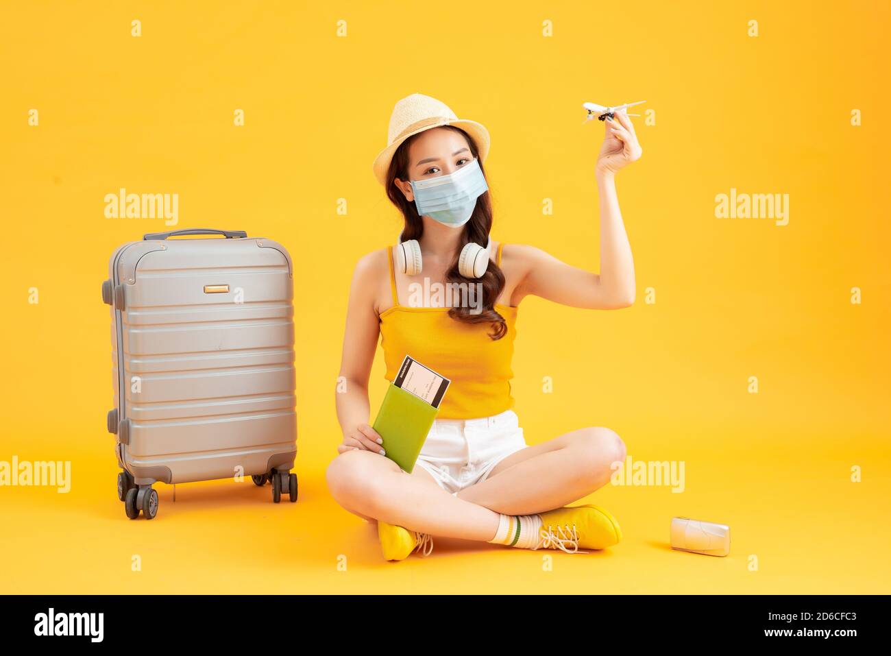 Junge asiatische weibliche Touristen tragen Maske der neuen normalen Lebensstil Tragen Sie einen Rucksack und Reisepass, um zu reisen, zu schützen Sich selbst von Virus Stockfoto