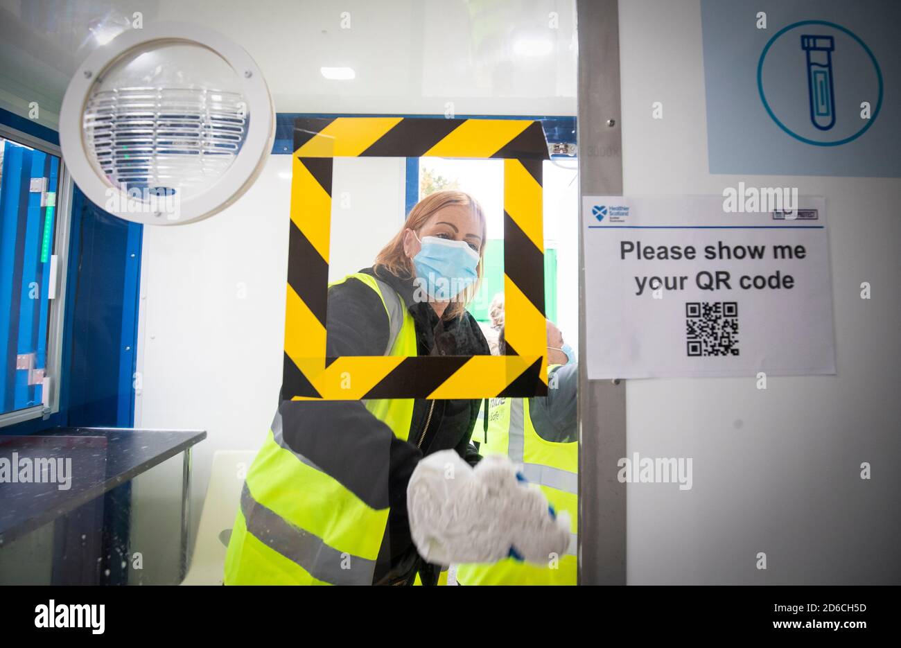 Ein Mitarbeiter reinigt den Testabgabebereich im neuen begehbaren Covid-Testzentrum in Dundee. Das Testzentrum verwendet ein System von angeschlossenen Anhängern, die mit Trockeneis gereinigt werden, der erste Standort in Schottland, der diese Fähigkeit hat. Stockfoto