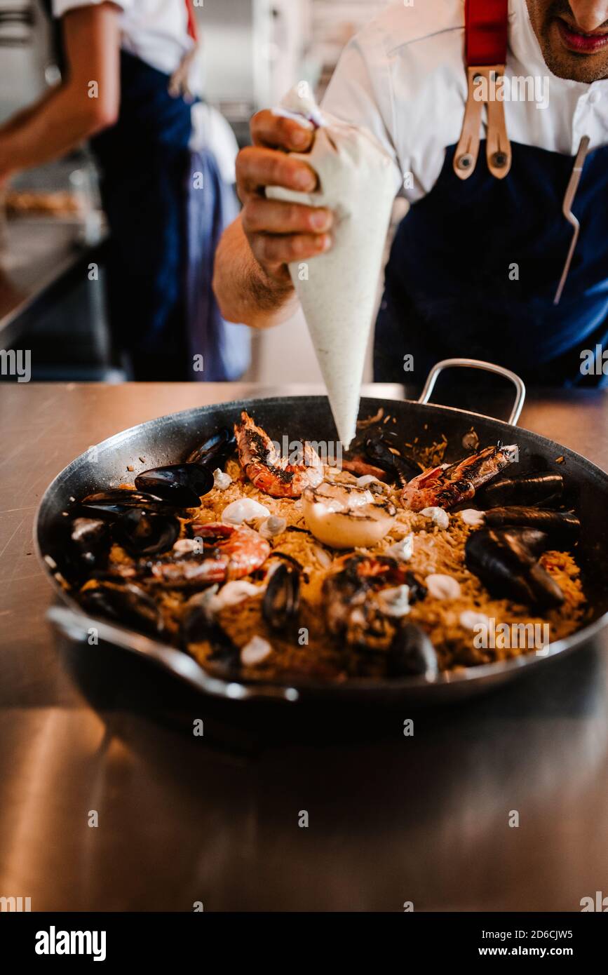 Koch bereitet Paella zu Stockfoto