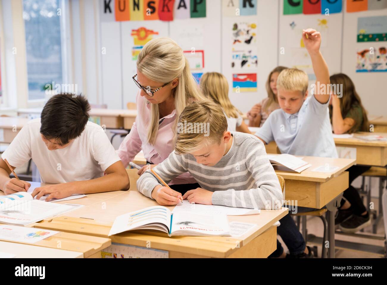 Lehrer hilft Jungen im Klassenzimmer Stockfoto