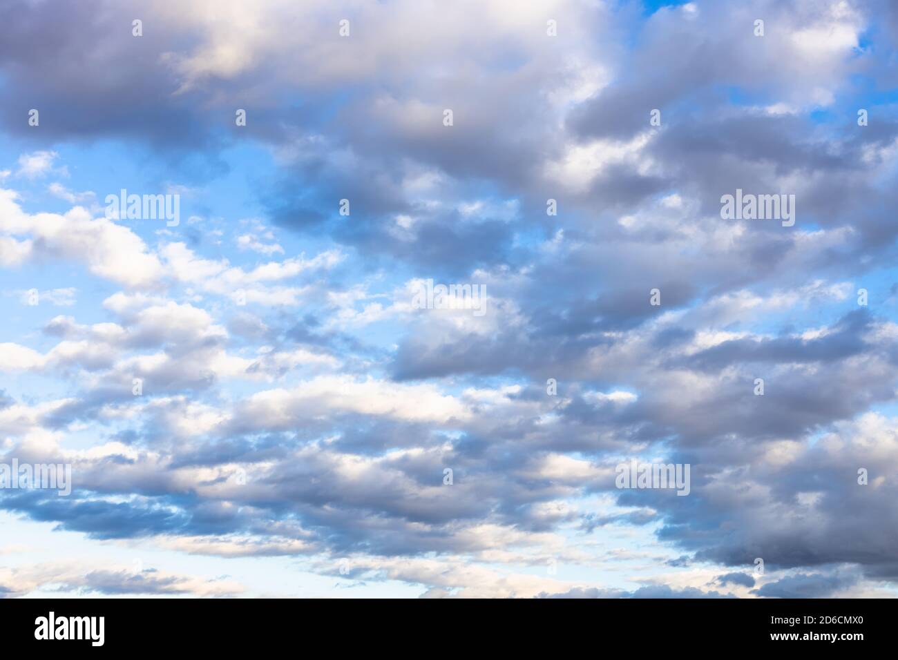 Viele graue und weiße niedrige Wolken im blauen Herbstnachmittag Himmel Stockfoto