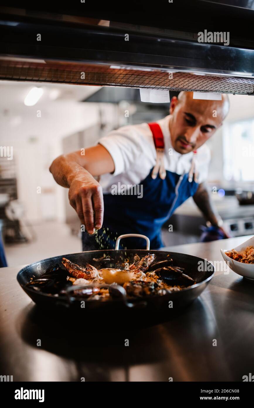 Koch bereitet Paella zu Stockfoto