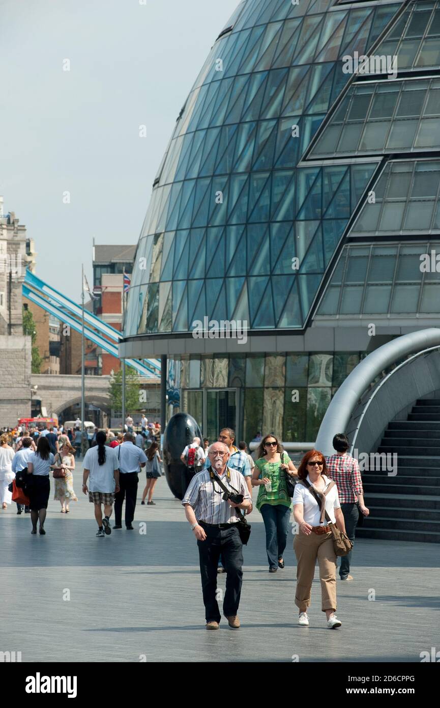 Touristen, die am Rathaus am Südufer, London, England vorbeilaufen. Stockfoto