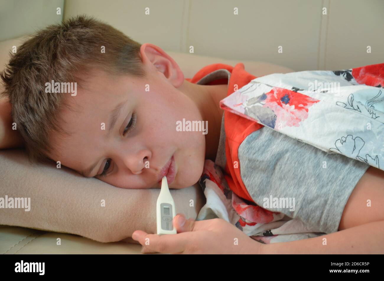 Kranker Teenager mit Thermometer im Bett. Fieber, Virus Stockfoto