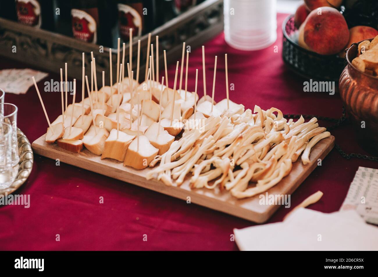 Seitenansicht eines Holzbretts mit Scheiben von verschiedenen Käsesorten auf Spieße. Catering. Stockfoto