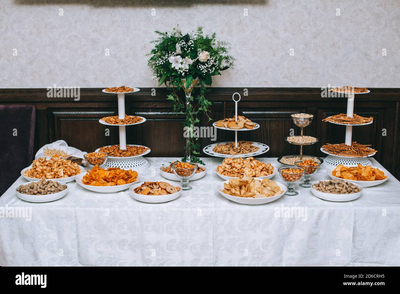 Catering-Tisch mit salzigen Snacks. Verschiedene Chips, Nüsse und Snacks. Stockfoto