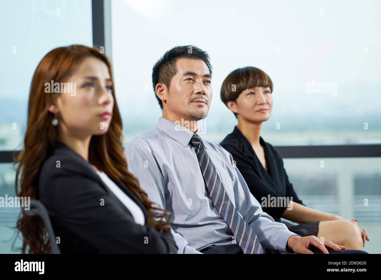 asiatische Führungskräfte hören während der Präsentation oder Schulung aufmerksam zu Stockfoto