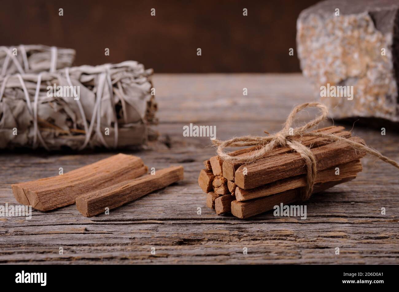 Energielieferung und Heilung.Holzstäbchen und weiße Salbeibündel auf dem Holzhintergrund. Stockfoto