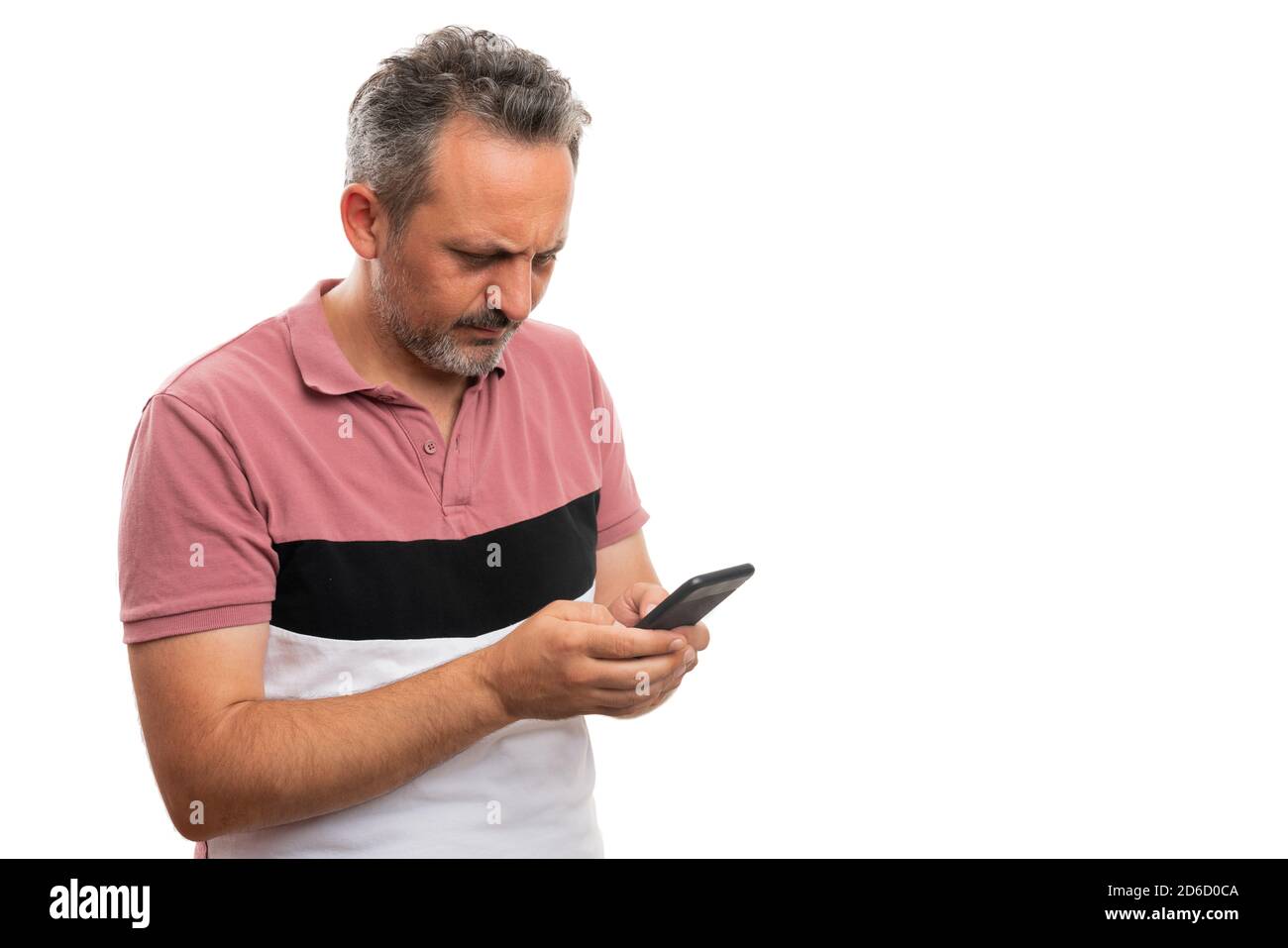 Erwachsene Mann macht ernsthaft denken Ausdruck tragen moderne stilvolle lässig Sommer Kleidung Blick auf Smartphone-Bildschirm als Text eingeben Nachricht mit bla Stockfoto