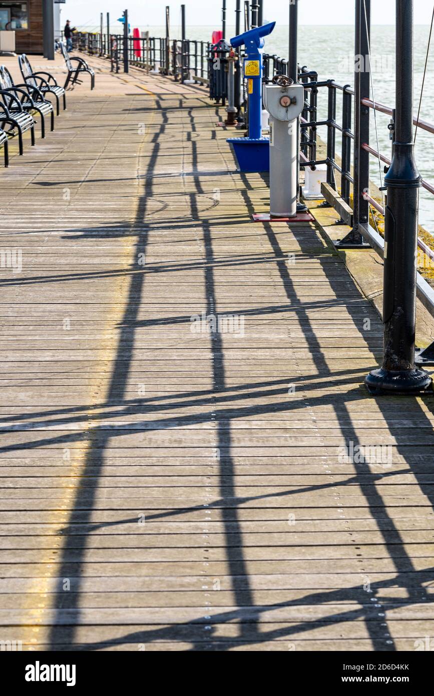 Schatten von Geländern am Ende des Southend Pier, Southend on Sea, Essex, Großbritannien. Teleskop. Sonniger, heller Herbsttag im Oktober, der einen Schatten erzeugt Stockfoto