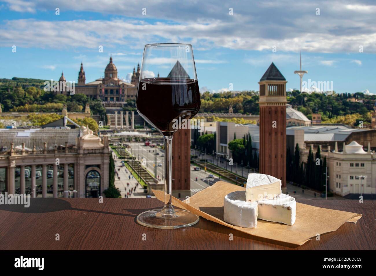 Glas Rotwein mit Brie-Käse vor dem Blick auf den Spanien-Platz in Barcelona, Spanien Stockfoto