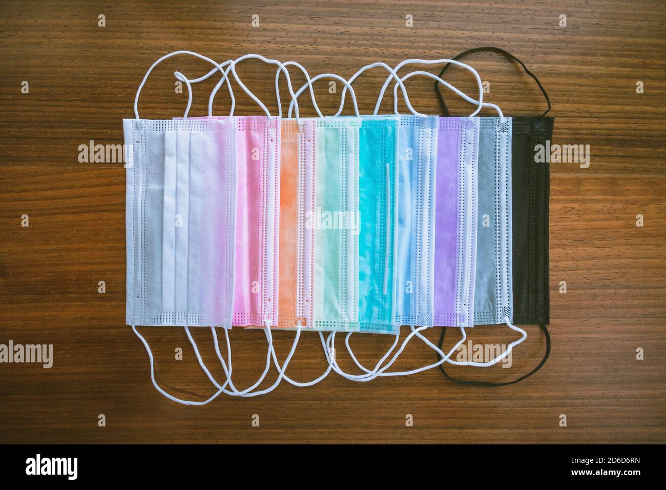 Bunte OP-Masken für Coronavirus (Covid-19) Schutz auf Holztisch. Schöne bunte Masken. Neuer normaler Lebensstil. Selektiver Fokus Stockfoto