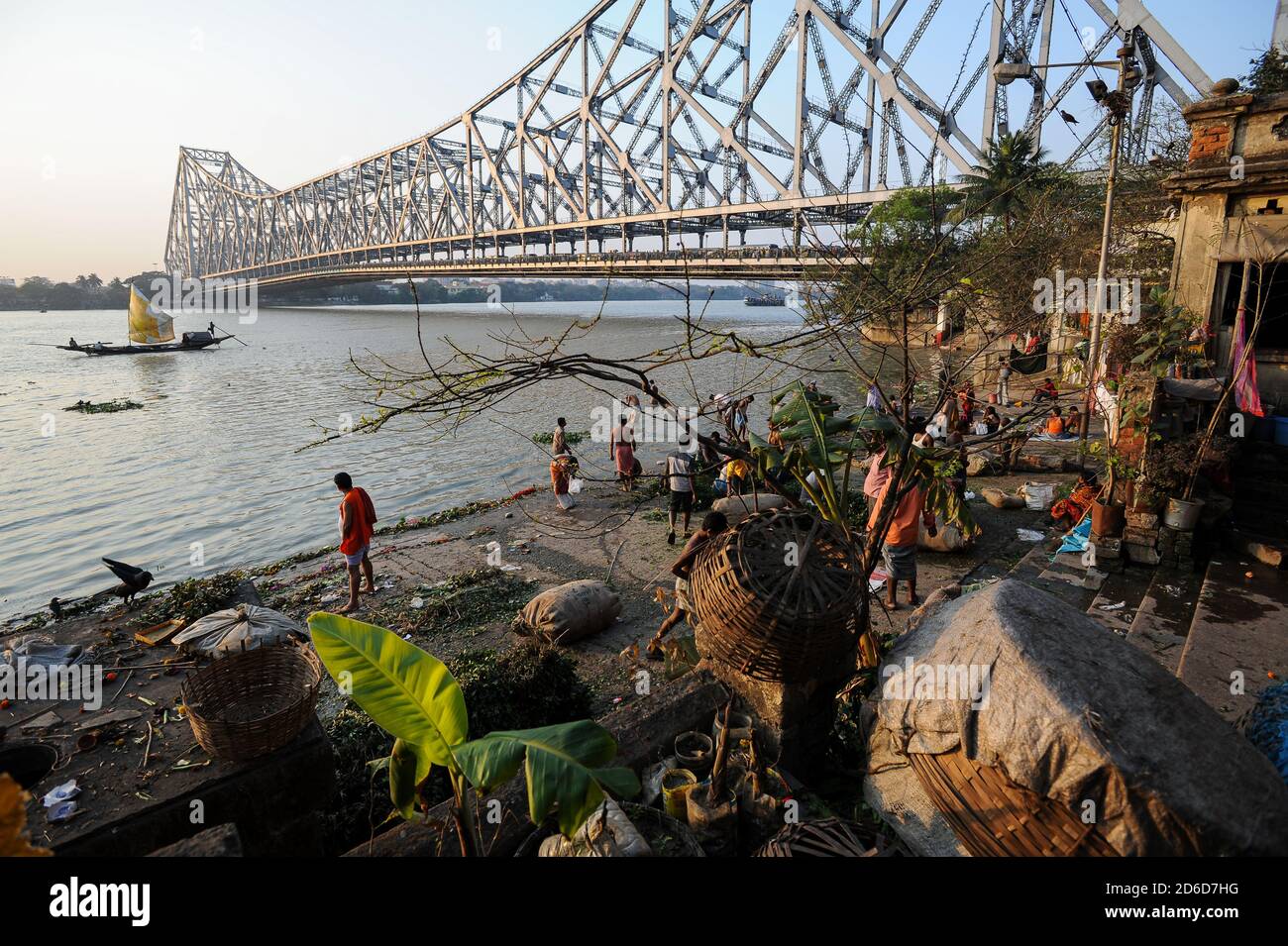 22.02.2011, Kalkutta, Westbengalen, Indien - Menschen bei Mallick Ghat am Ufer des Hugli-Flusses mit der Howrah-Brücke im Hintergrund verbunden Stockfoto