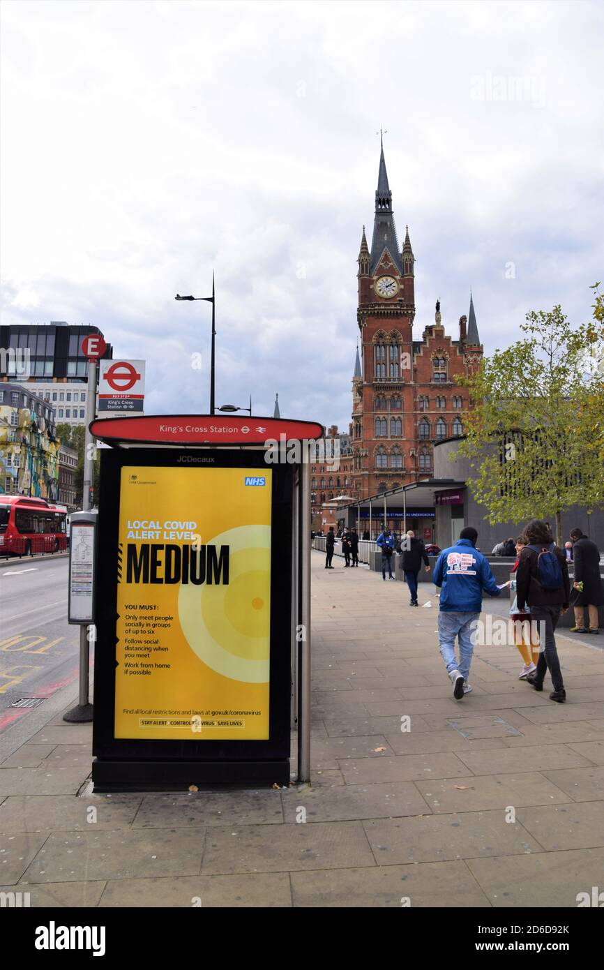 Local Covid Alert Level Mittleres Schild an einer Bushaltestelle in Kings Cross, London. Die britische Regierung hat ein neues dreistufiges System eingeführt, bei dem die Beschränkungen je nach Niveau in den einzelnen Gebieten steigen. Stockfoto