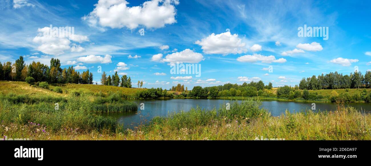 Helle Sommer-Panorama-Landschaft mit schönen See und grünen Hügeln Stockfoto