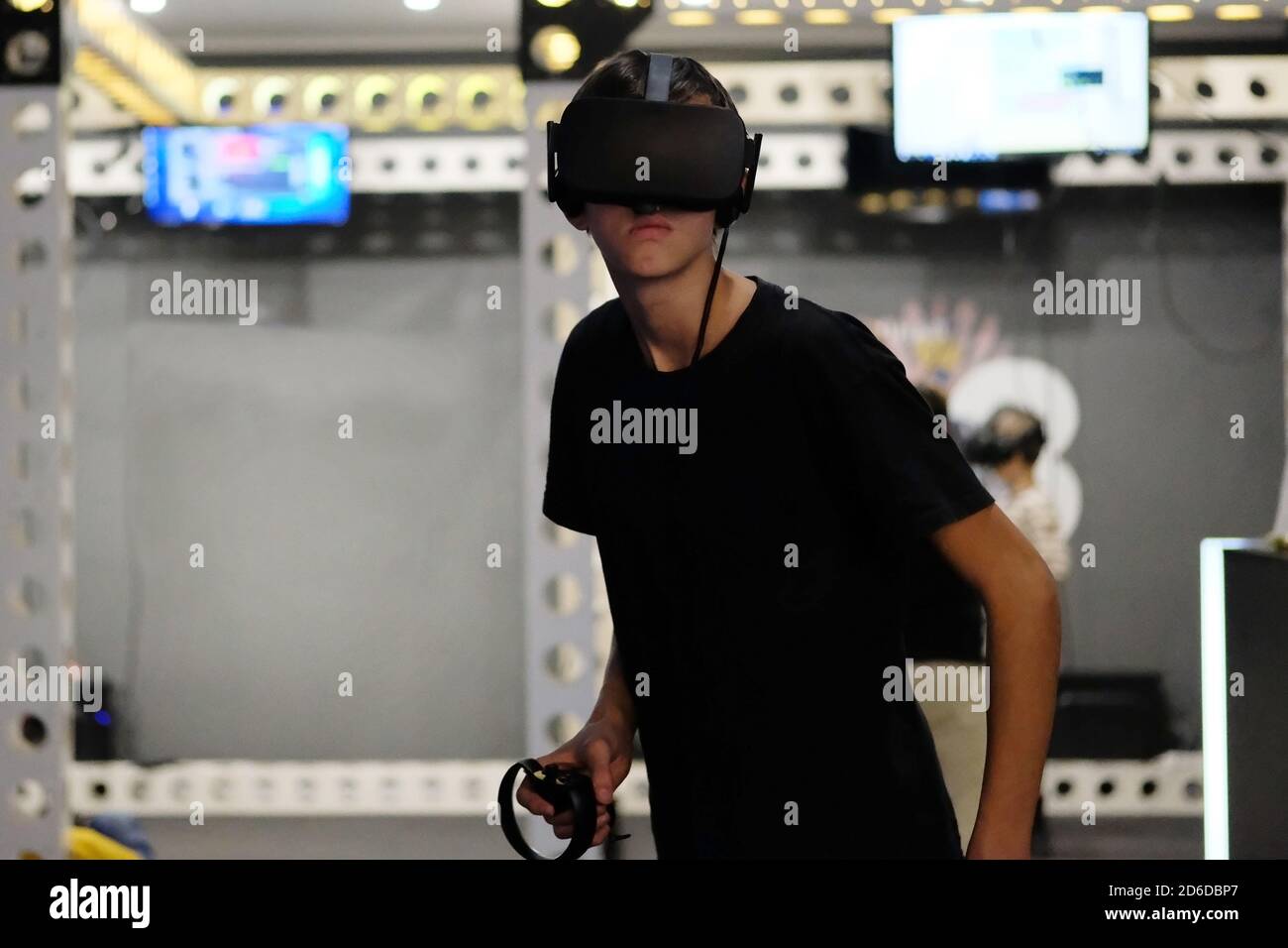 Teenager in Virtual-Reality-Brille in hellen modernen Quest-Raum. Aufregende Technologie. Stockfoto