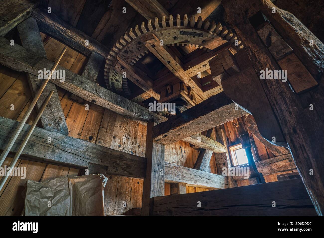 Ein Holzzahnrad einer historischen Windmühle. Industrielles Interieur mit einem gezahnten Windmühle Getriebe, Teil einer Fräsmaschine, vermittelt Vintage-Konzept Stockfoto