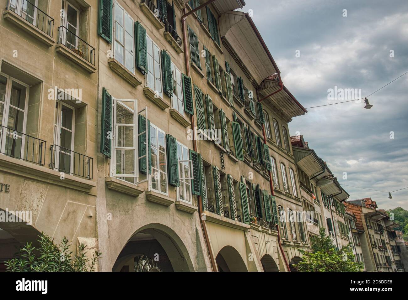 Reihenhäuser außen über einer Arkaden im Berner Altstadtviertel mit vielen bunten, alten Lamellen oder Lamellenverschlüssen (Jalousie) Stockfoto