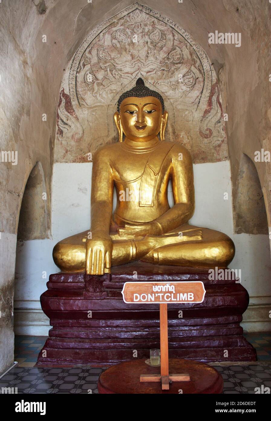 Goldfarbene Buddha-Statue mit Schilder Besteigen Sie nicht am Ananda Tempel in Bagan, Myanmar Stockfoto
