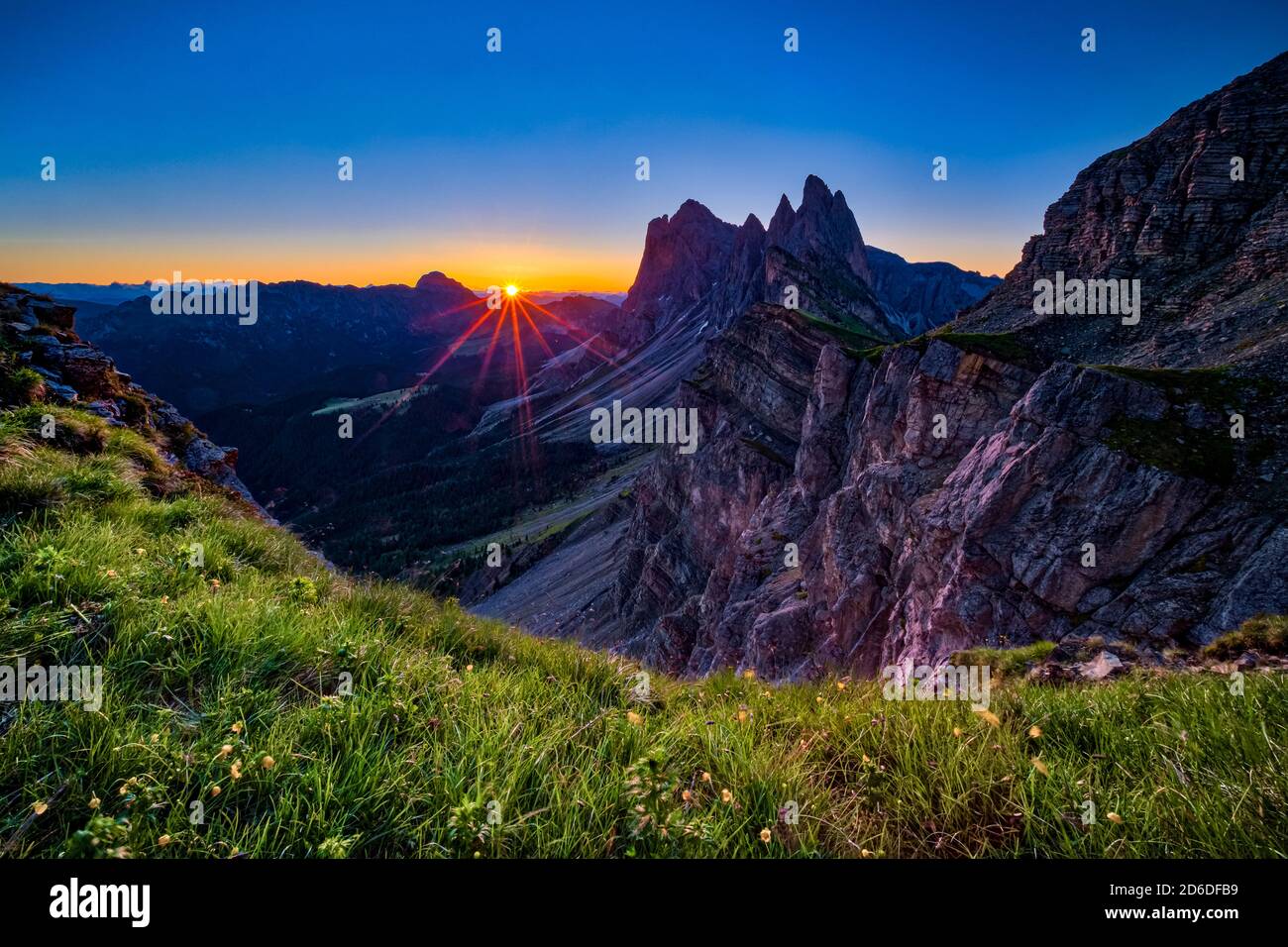 Sonne geht hinter den steilen, rauen Klippen und Gipfeln der Gebirgsformation Seceda auf, Secèda, Teil des Naturparks Puez-Geisler, Parco naturale P Stockfoto