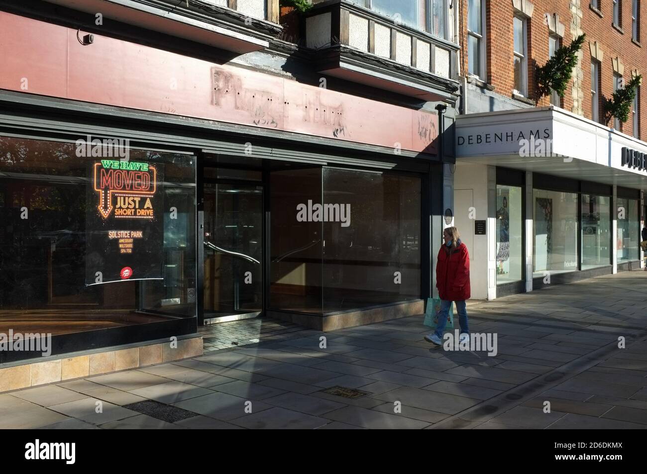 Ein Einzelkäufer passiert zwei kürzlich geschlossene große Namen auf der High Street - Pizza Hut und Debenhams - in Salisbury UK Okt 2020. Stockfoto