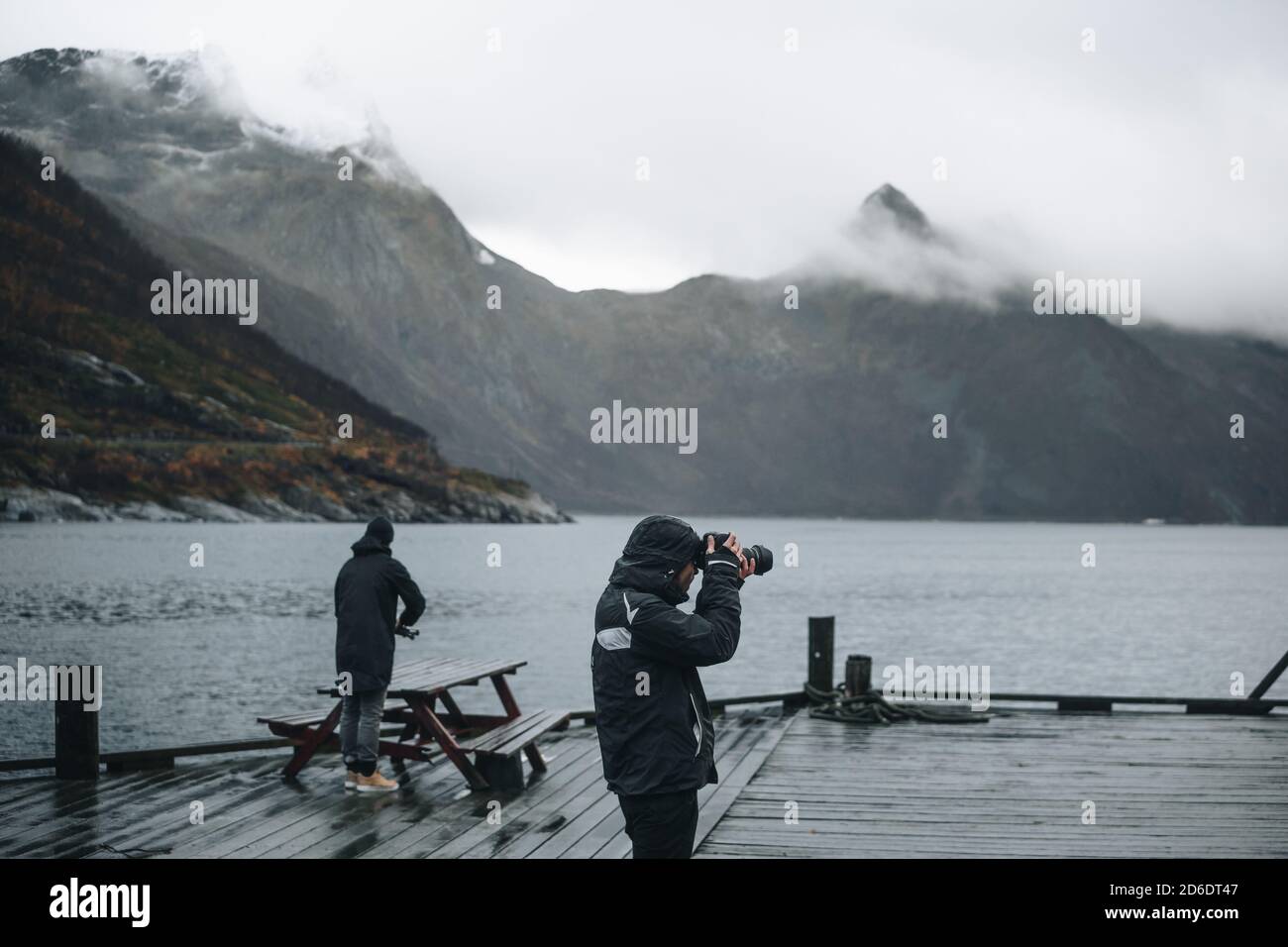 Zwei junge Männer fotografieren die stimmungsvolle Szene in den Fjorden von Senja, Norwegen Stockfoto
