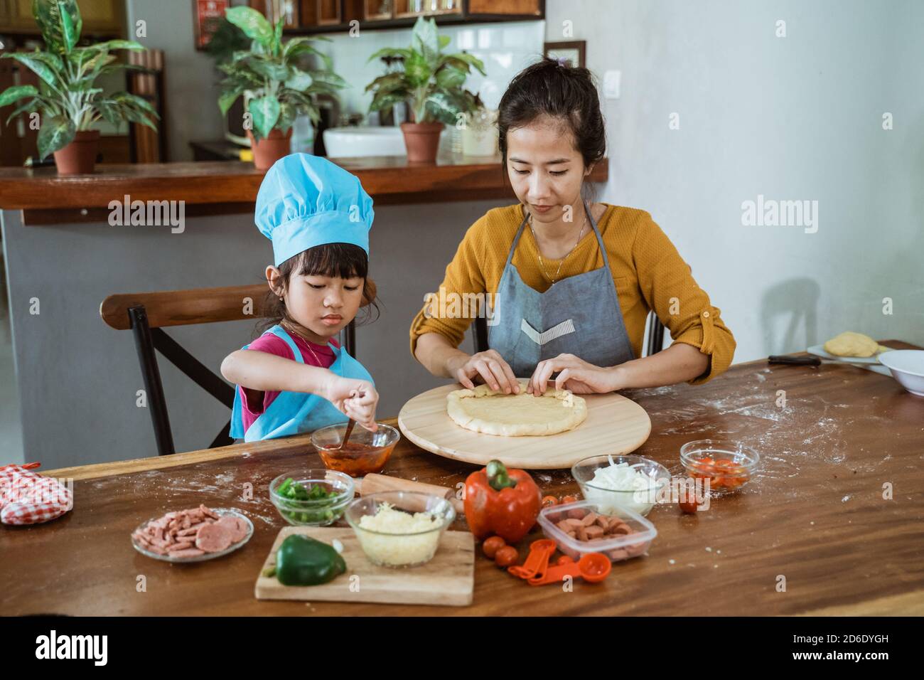 Mutter und Tochter, die Pizza in der Küche vorbereiten Stockfoto