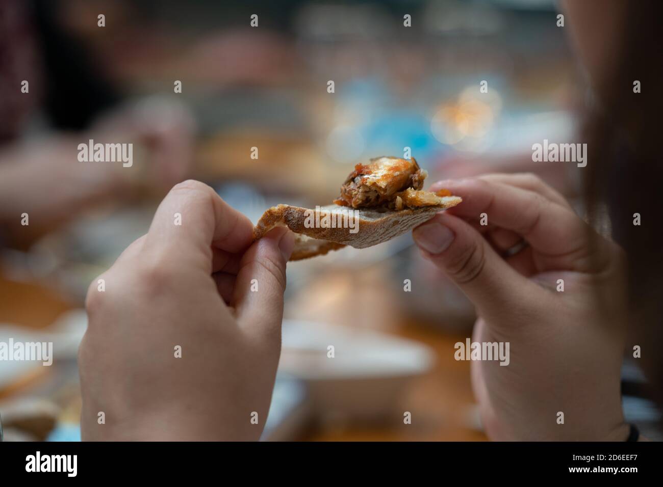 Das Brot halten, um den Fisch aus der Dose zu probieren Stockfoto