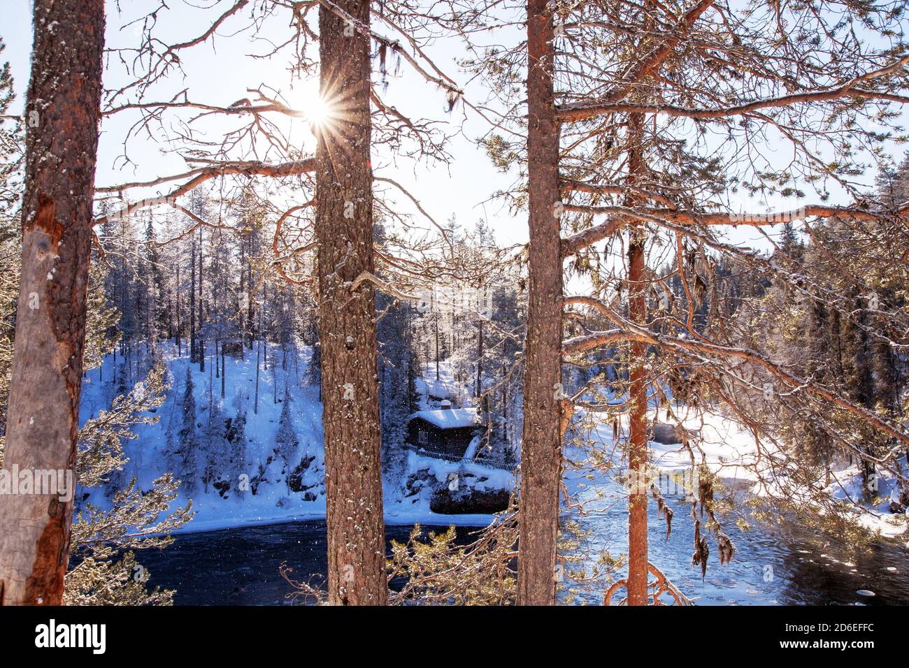 Eine kleine gemütliche Winterhütte am Fluss im finnischen Taigawald, Nordeuropa. Stockfoto