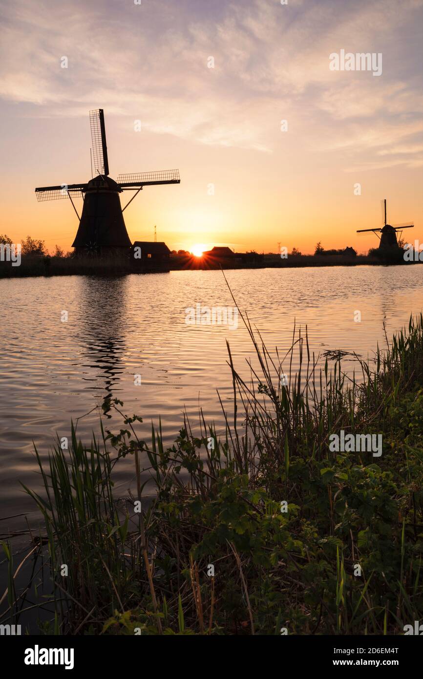 Windmühle bei Sonnenaufgang, Kinderdijk, UNESCO-Weltkulturerbe, Südholland, Niederlande Stockfoto