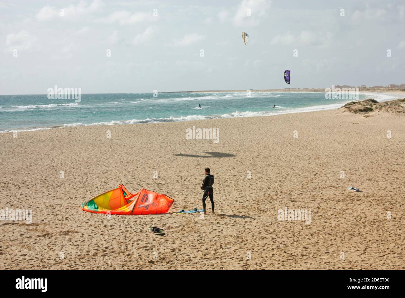 Kitesurfer steht am Strand mit seiner Ausrüstung Stockfoto