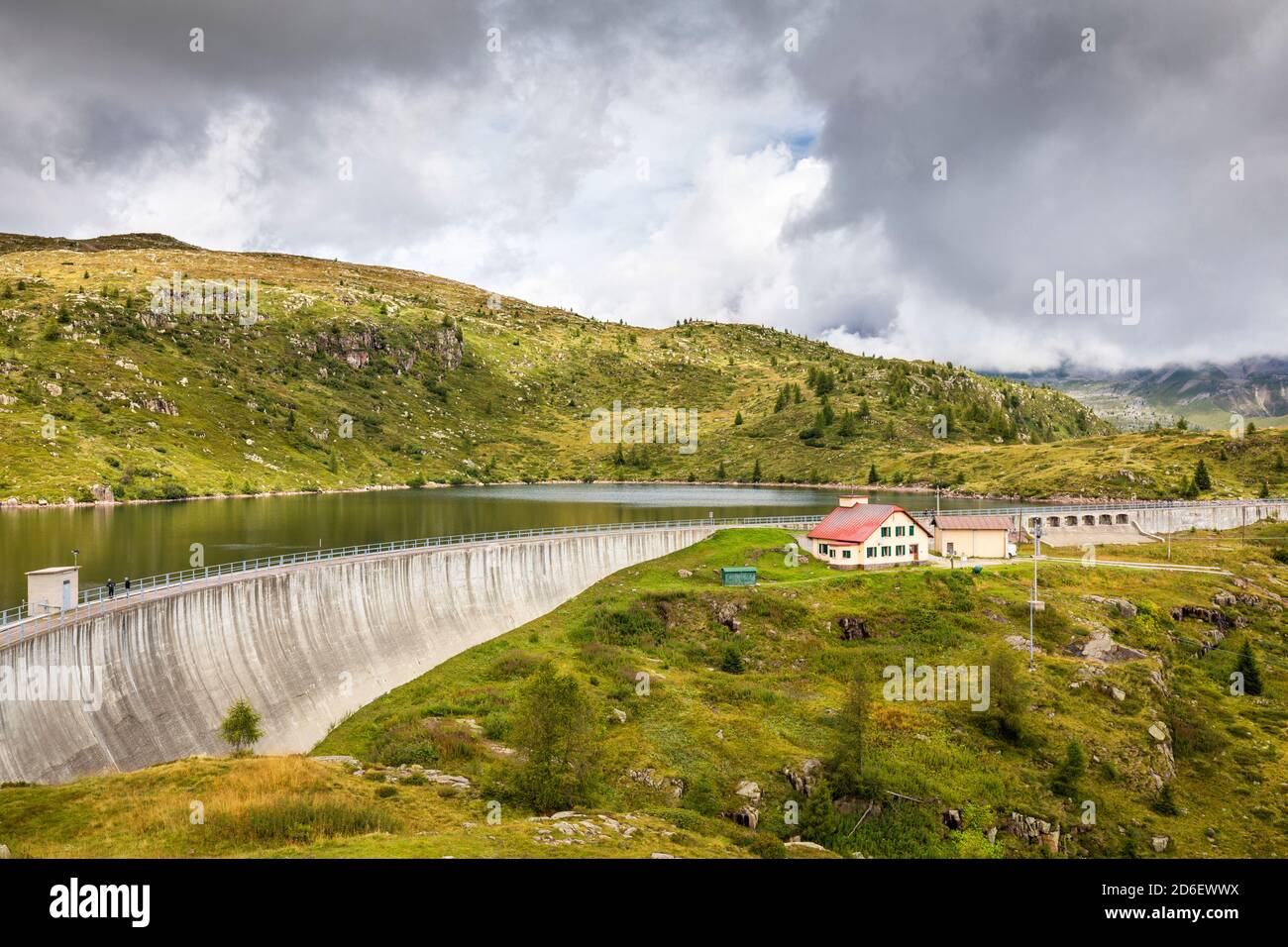 Der Cavia Damm mit Lago del Cavia an einem bewölkten Tag, das Schutzhaus mit dem roten Dach, falcade, belluno, venetien, Italien Stockfoto