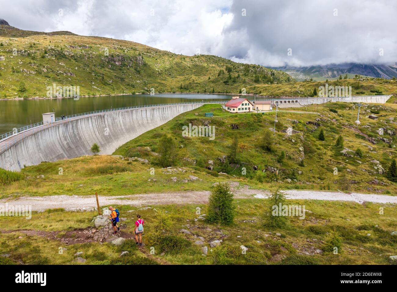 Der Cavia Damm mit Lago del Cavia an einem bewölkten Tag, das Schutzhaus mit dem roten Dach, falcade, belluno, venetien, Italien Stockfoto