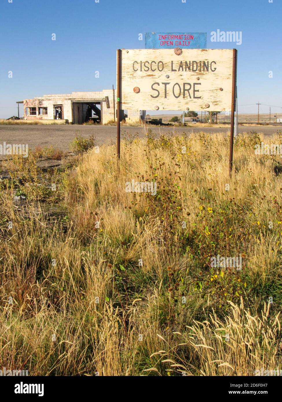 Eine alte Namenstafel für den Laden mit einer Ruine im Hintergrund in der Geisterstadt Cisco Landing, einer alten Bahnhofsstadt in Utah, USA Stockfoto