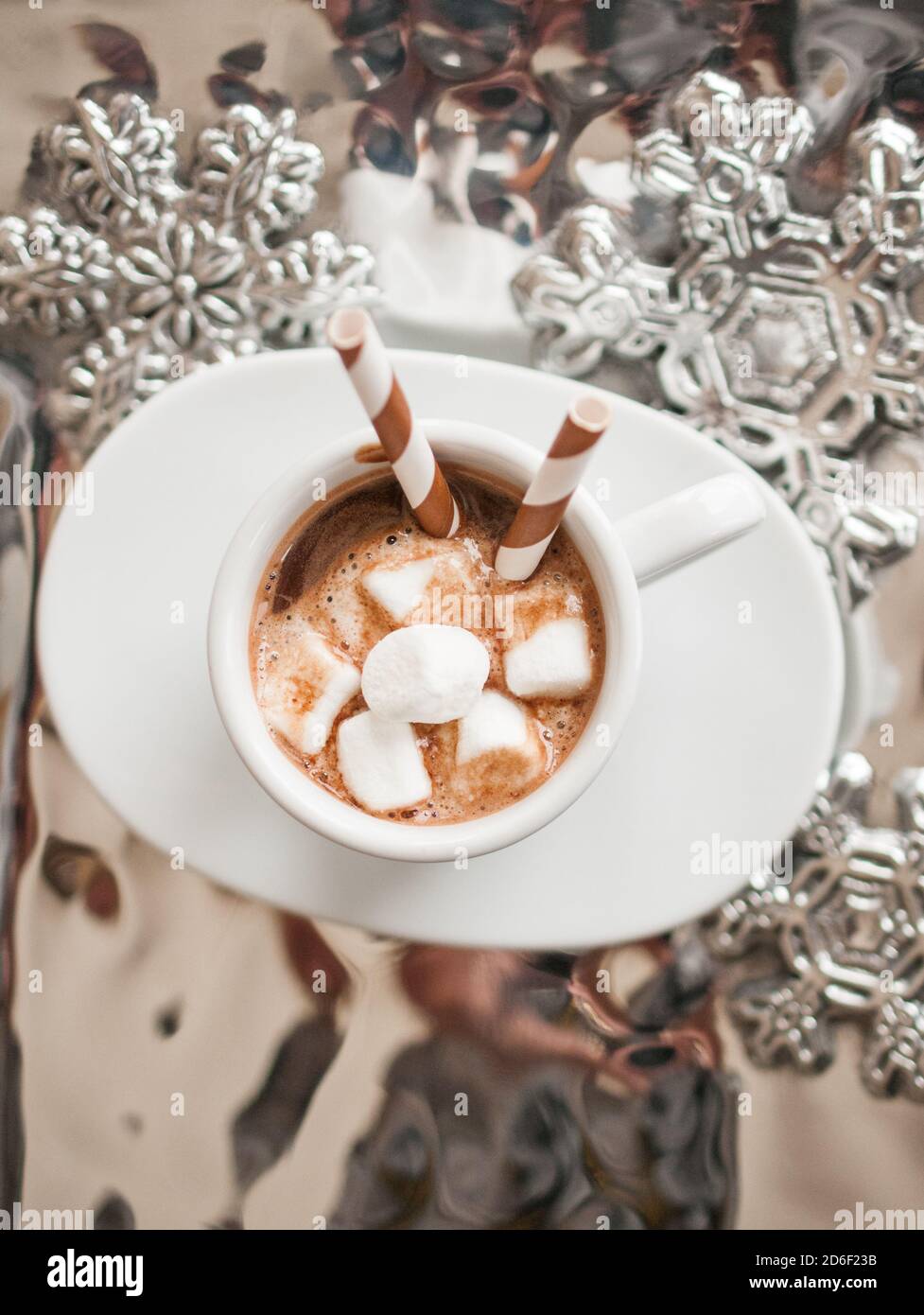 Overhead Foto von einer weißen Tasse heiße Schokolade mit Mini Marshmallows und gestreifte Trinkhalme auf einem silbernen Tablett Stockfoto