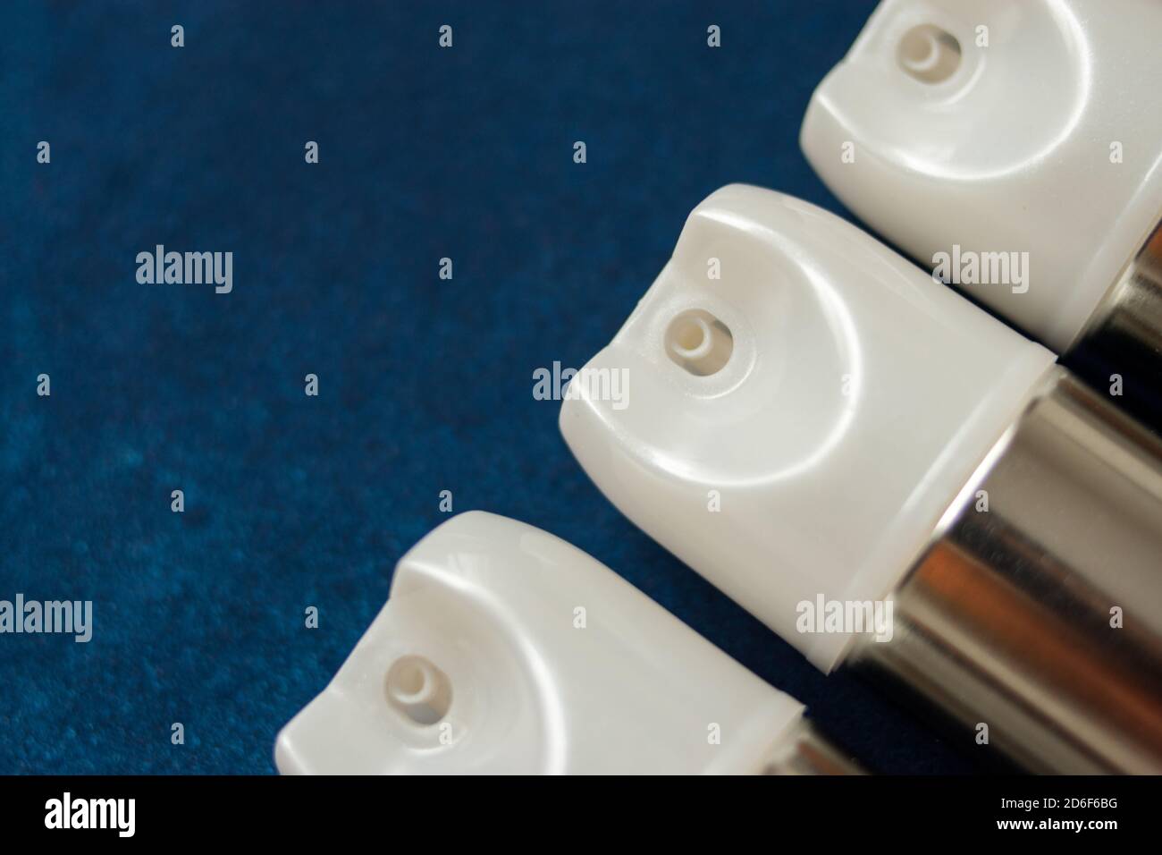 Einige Metall-Aerosoldosen mit weißer Oberseite auf einem bunten Tabelle Stockfoto